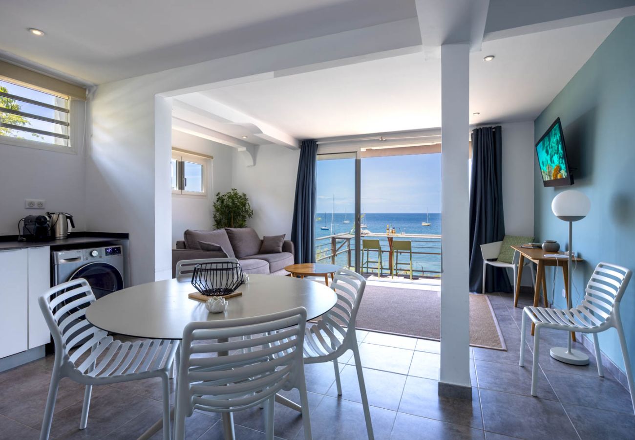  Modern interior of Apartment Ti Soleil: dining table and comfortable living room with sea view in Martinique.