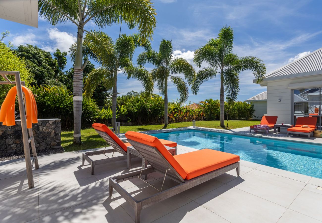 Orange sun loungers by the swimming pool at Villa Koulirou Corail in Guadeloupe