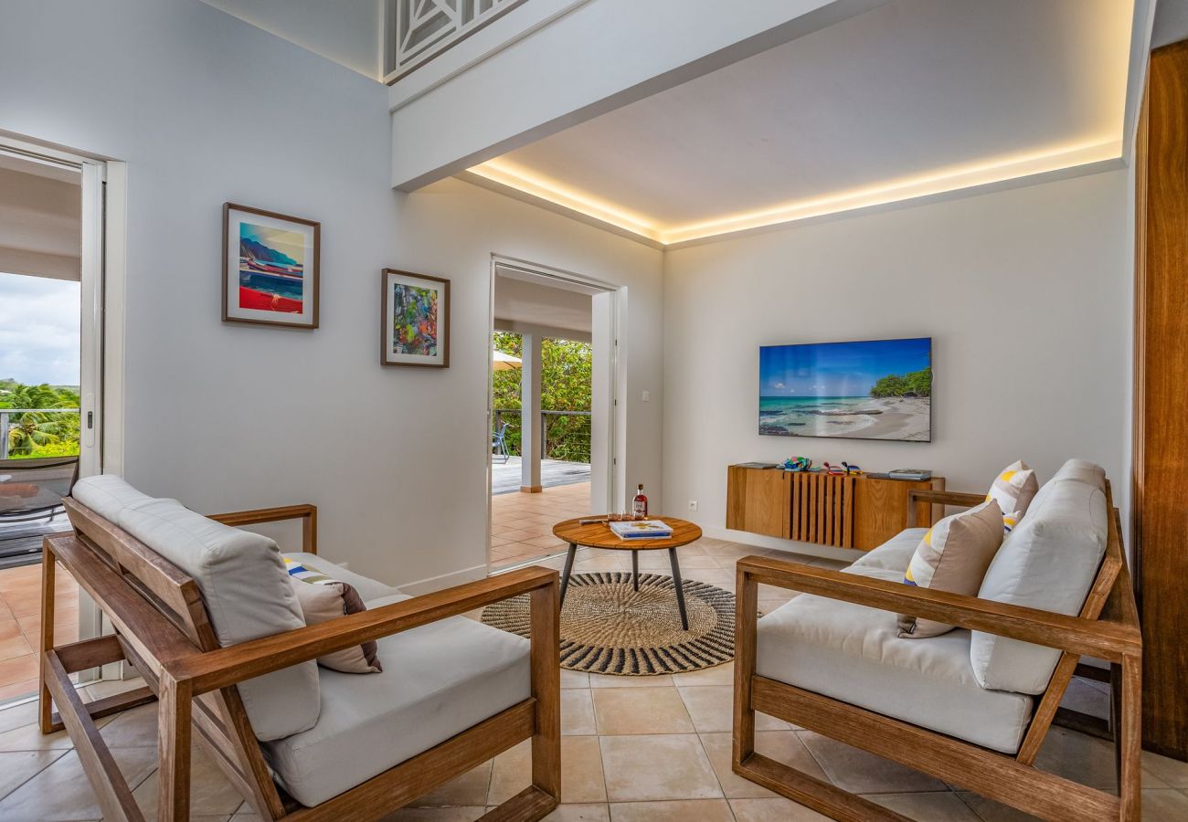 Contemporary living room with wide openings overlooking the terrace and pool at Villa Garden Bay.