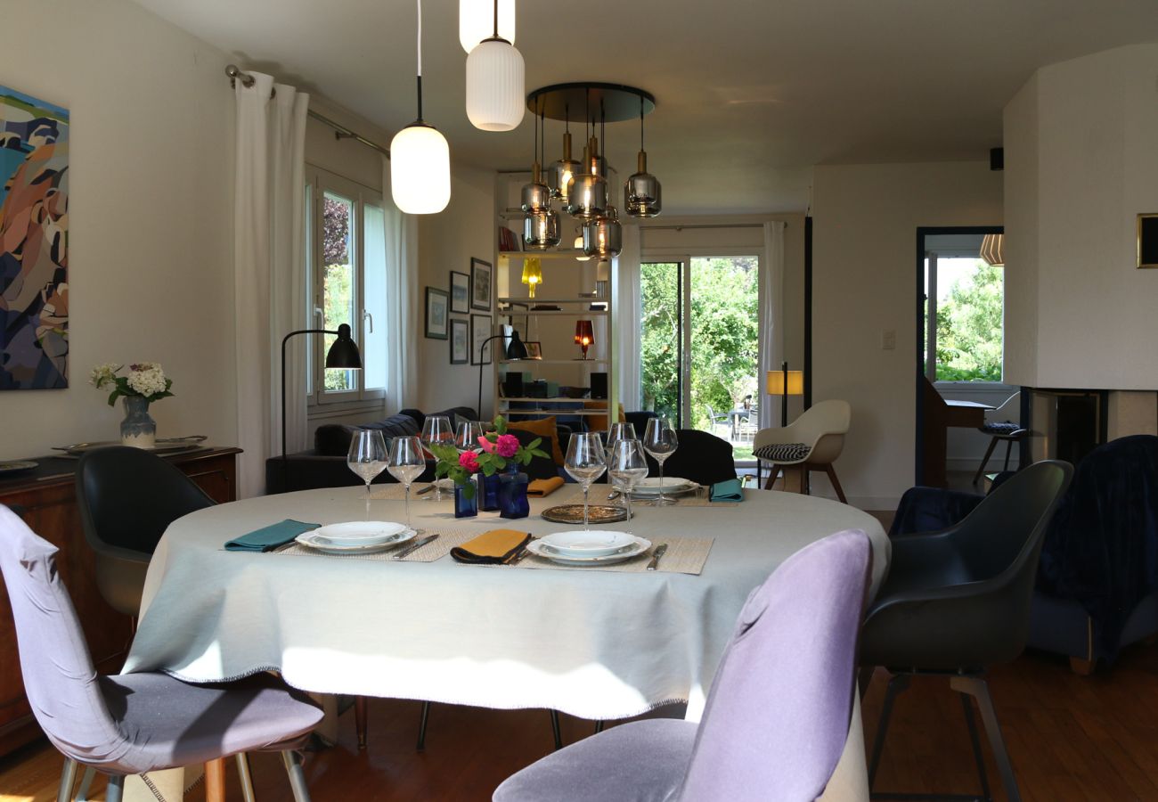 Living room and dining room in a rental property in Saint-Malo with large windows overlooking the garden