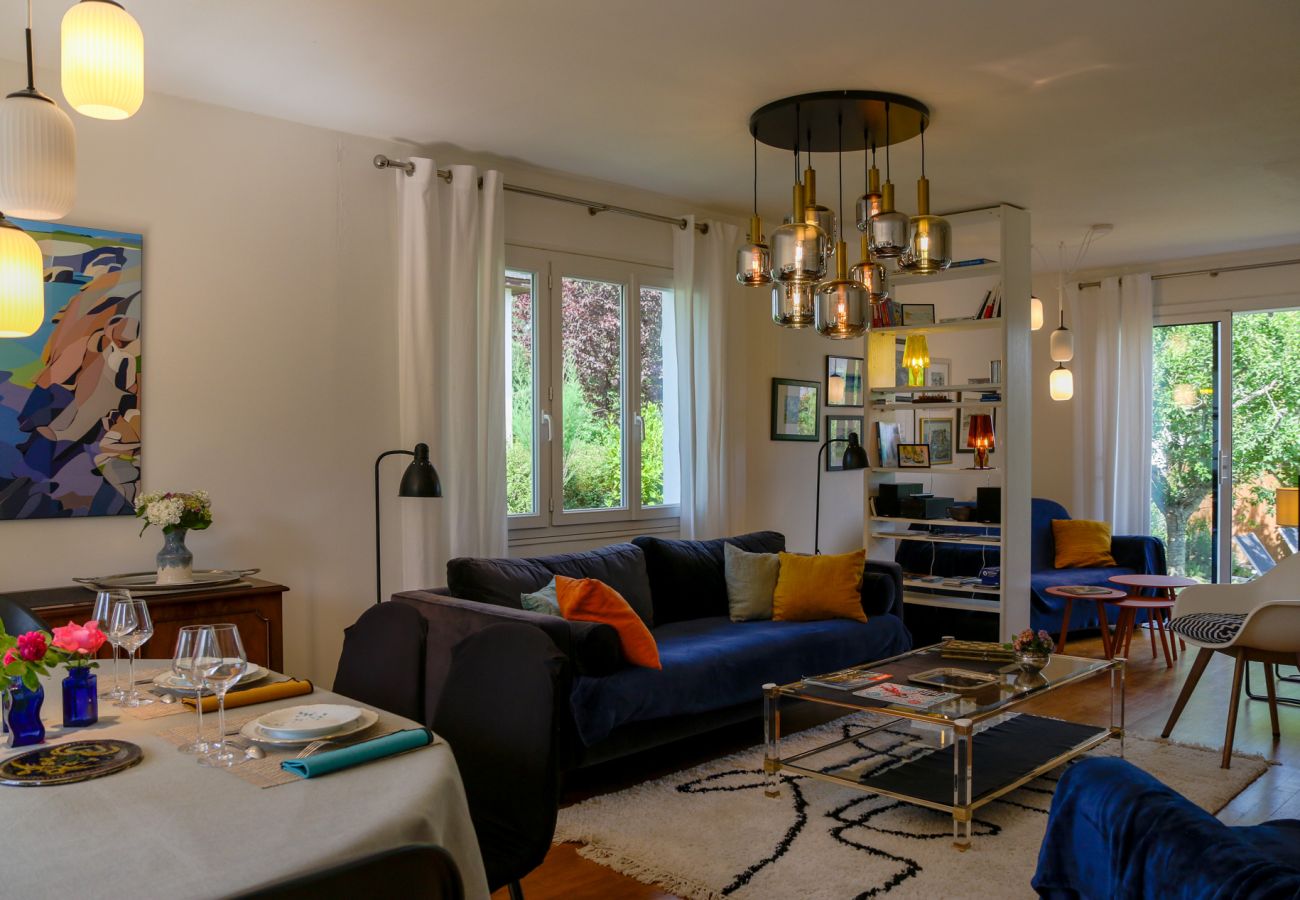 Living room and dining room of a villa in Saint-Malo with large windows overlooking the garden