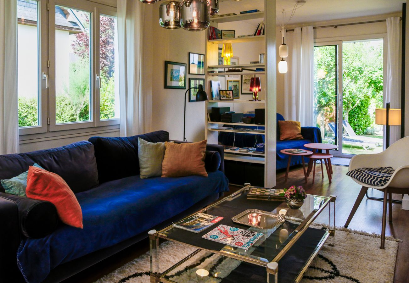 Living room and dining room in a rental in Saint-Malo with large windows overlooking the garden