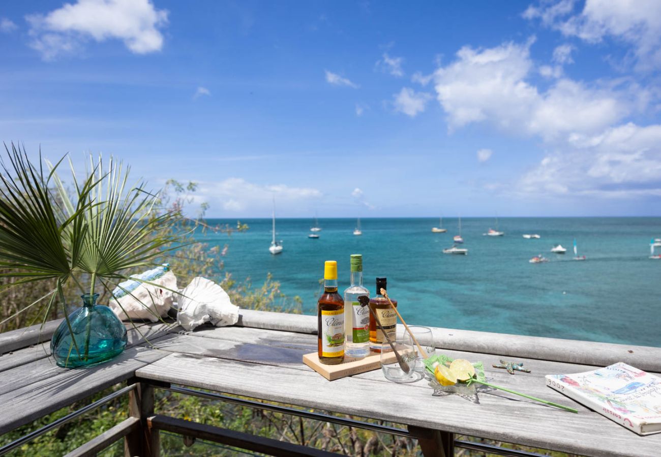 Vue mer depuis la terrasse de la Villa Ti Soleil aux Anses-d'Arlet avec plateau de Ti-Punch face aux bateaux de la baie.