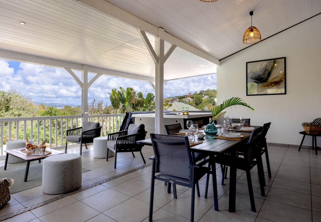 Terrasse moderne de la Villa Émeraude avec salon, table à manger et vue nature aux Trois-Îlets.