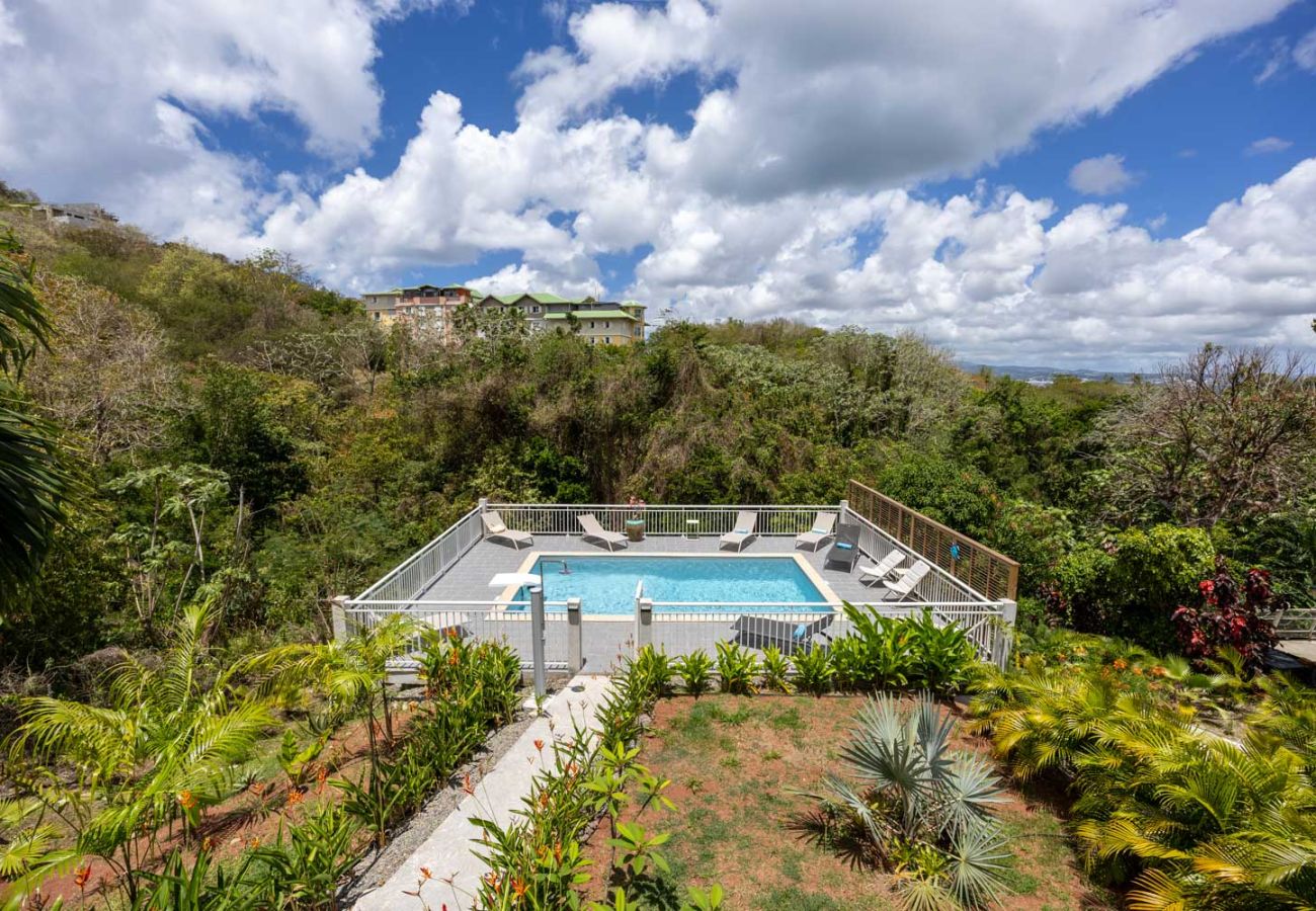Vue aérienne du jardin luxuriant et de la piscine de la Villa Émeraude, nichée dans la nature des Trois-Îlets, Martinique.