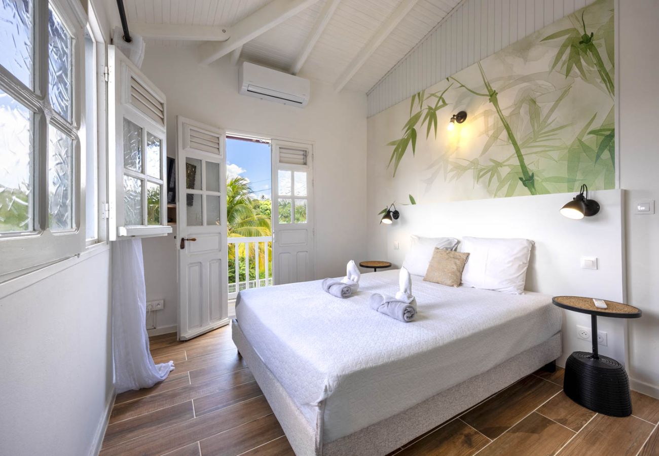 Chambre double climatisée ouverte sur la végétation, Villa Émeraude.