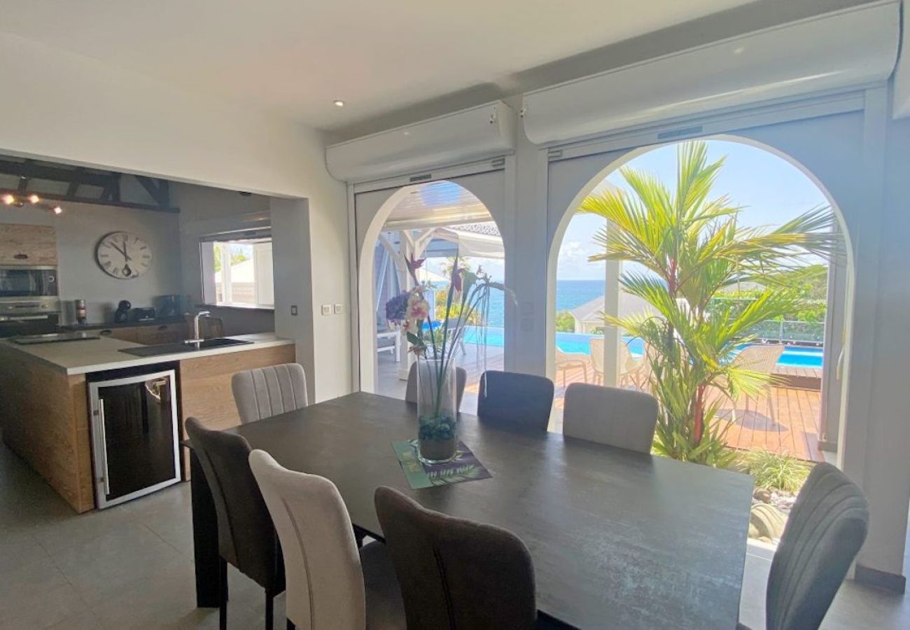 Espace repas intérieur ouvert sur la terrasse et la piscine, Villa Lazulia