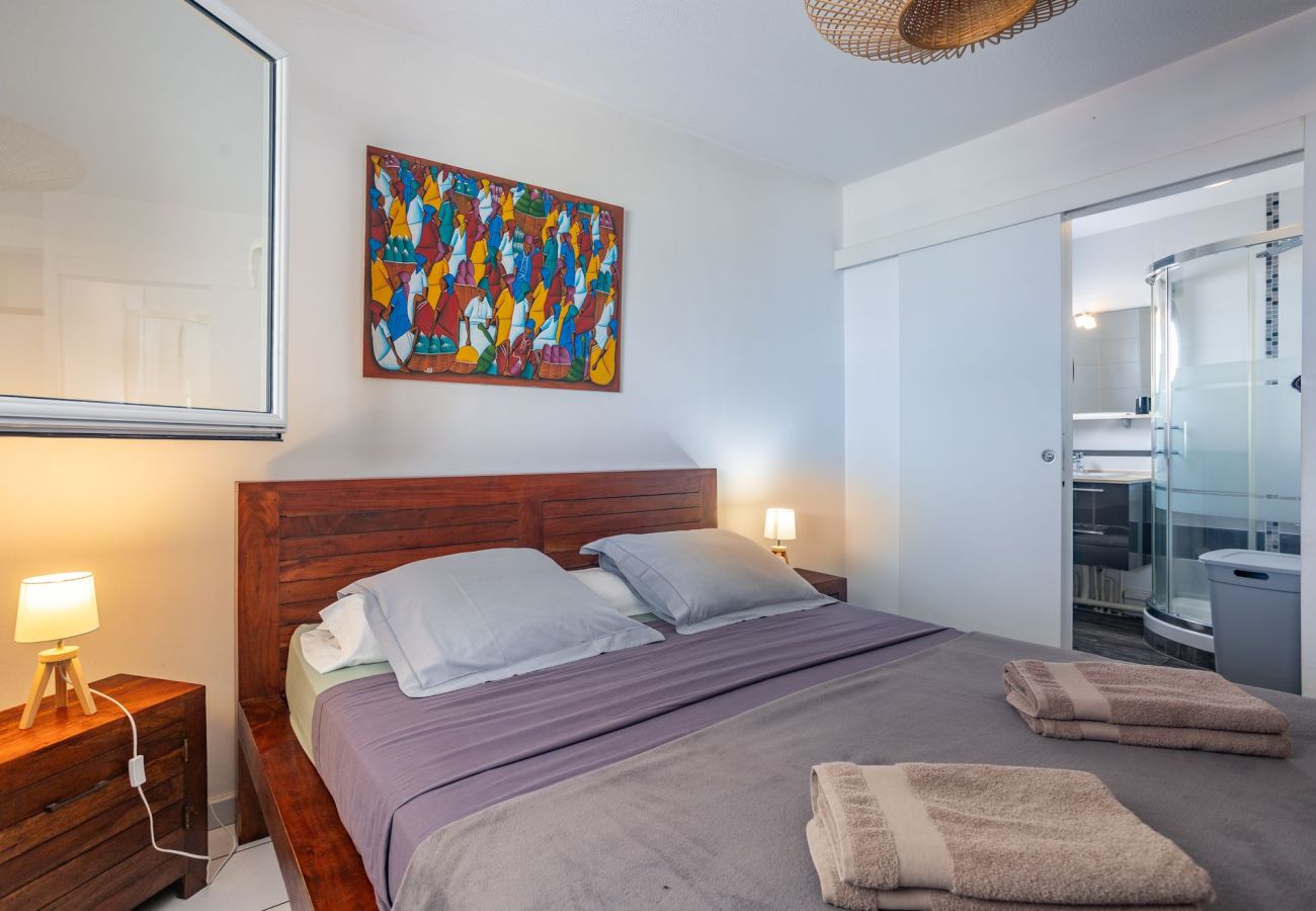 Chambre parentale avec vue mer et salle d'eau privative à l'appartement Ti'Bato aux Trois-Îlets, Martinique.