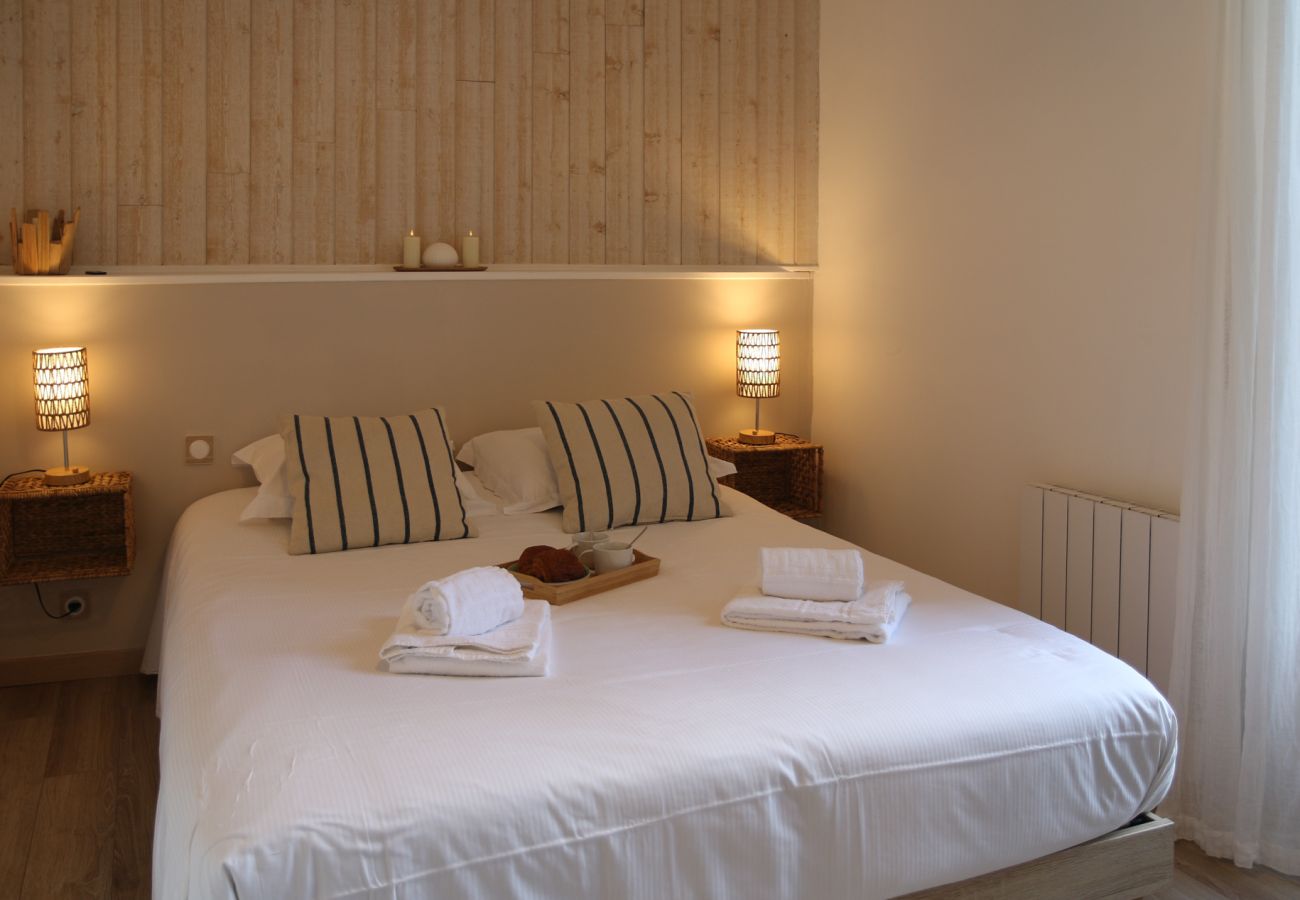 Chambre double avec lit confortable, linge blanc et décoration naturelle dans un appartement à Cancale