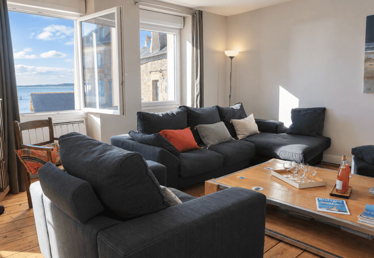 Salon confortable avec canapé, et vue sur la mer dans l'appartement à Cancale.